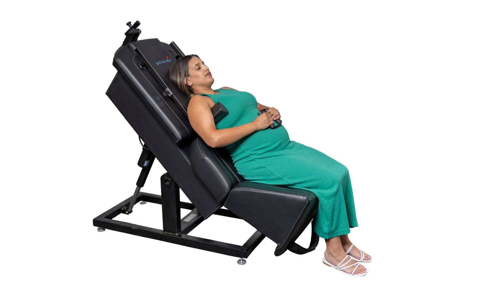 An expecting mother seated and slightly reclined in the treatment chair, one hand resting on her belly